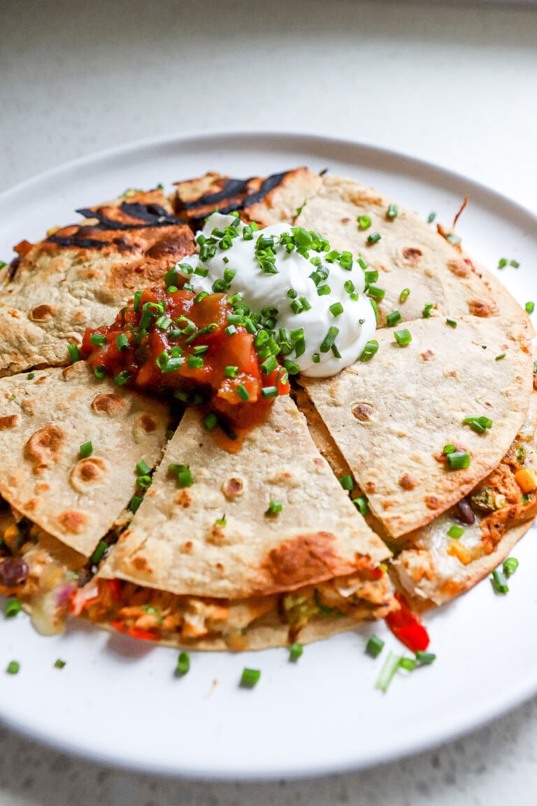 Side angle of an easy air fryer quesadilla with salsa and sour cream.