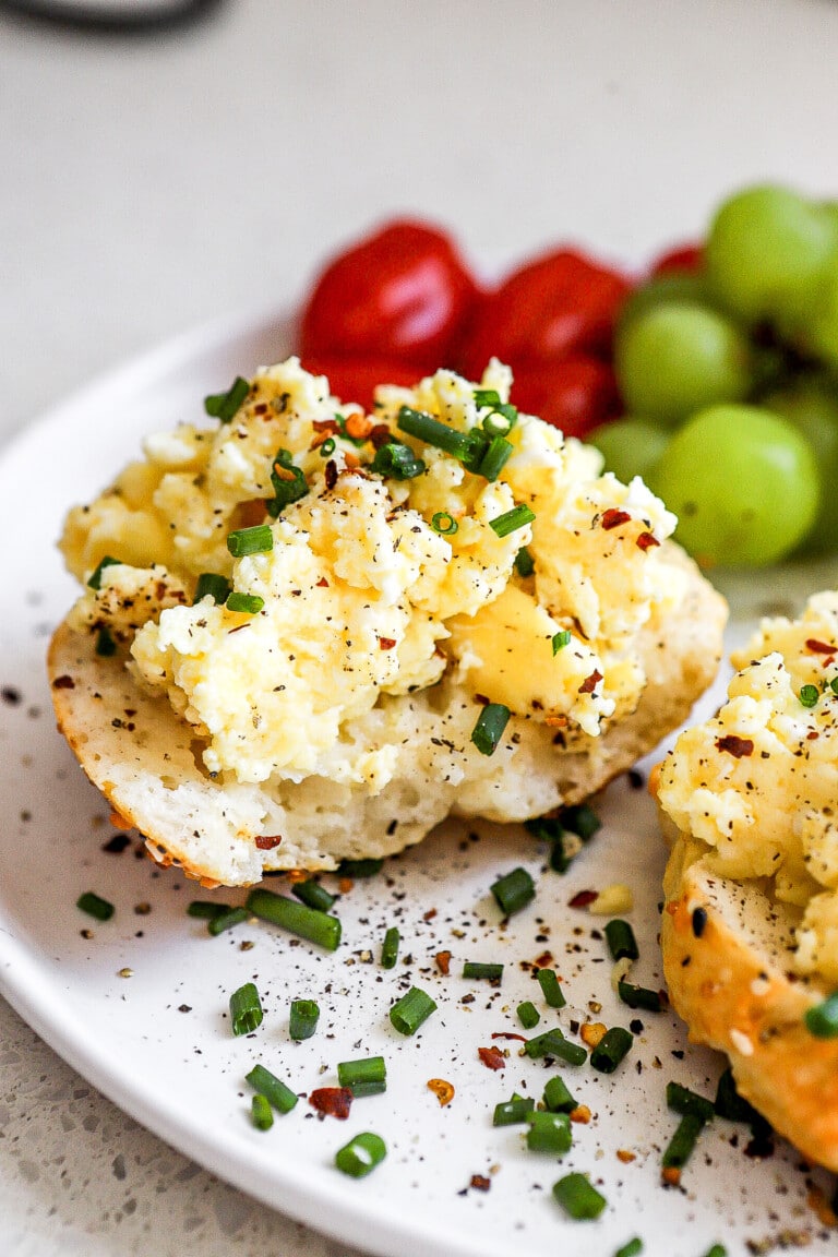 Close up view of high protein breakfast on small white plate with chives and black pepper.
