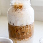 High protein iced coffee in a mason jar with layers of espresso and protein milk