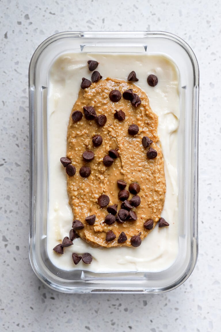 Top down view of greek fluffy yogurt with peanut butter on top and chocolate chips.