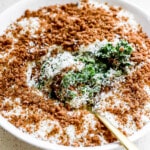 Side angle of viral caesar salad with parmesan and breadcrumbs on top.