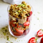 Side view of dubai chocolate strawberry cup with pistachios on top.