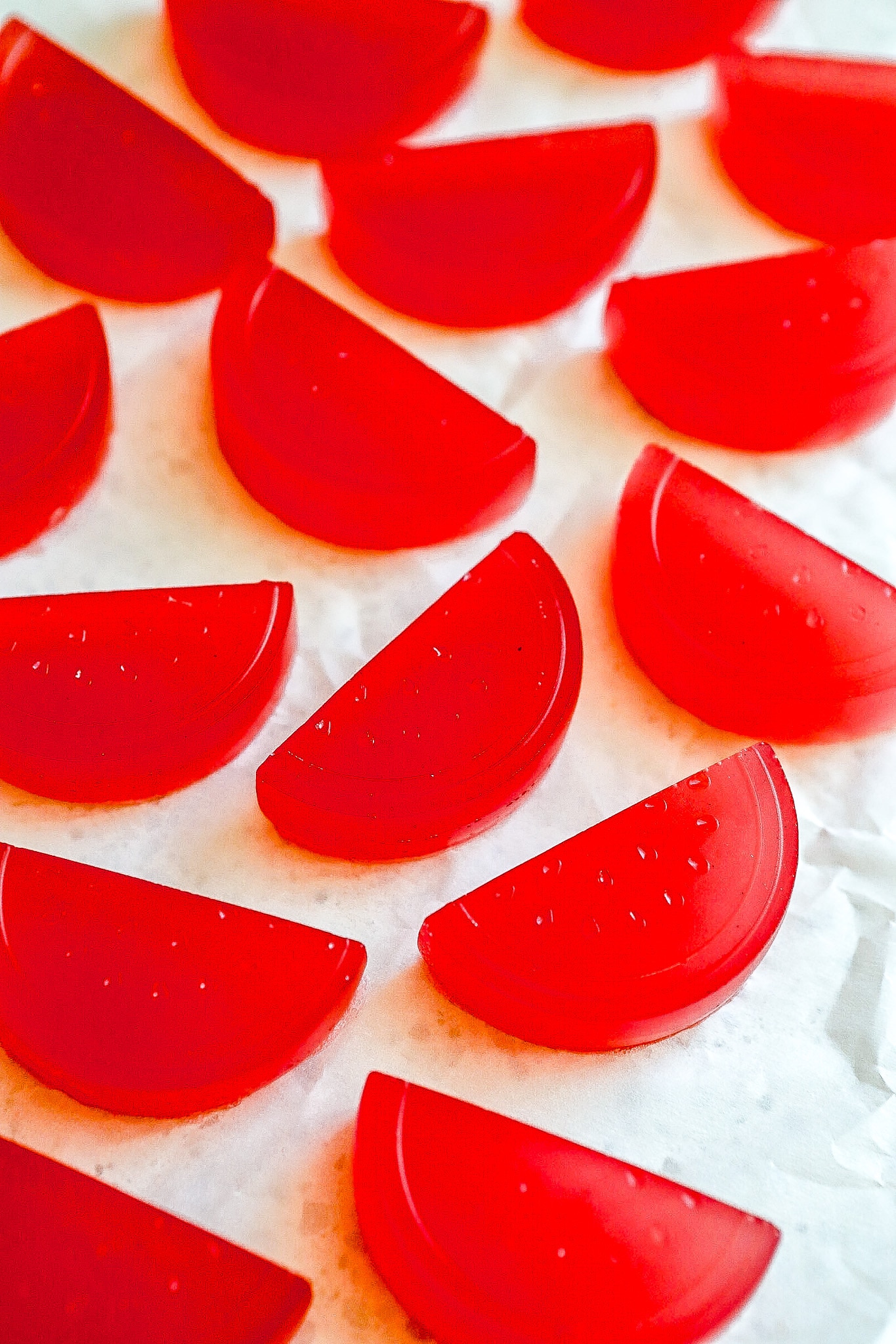 Side angle of protein watermelon gummies on white backdrop.