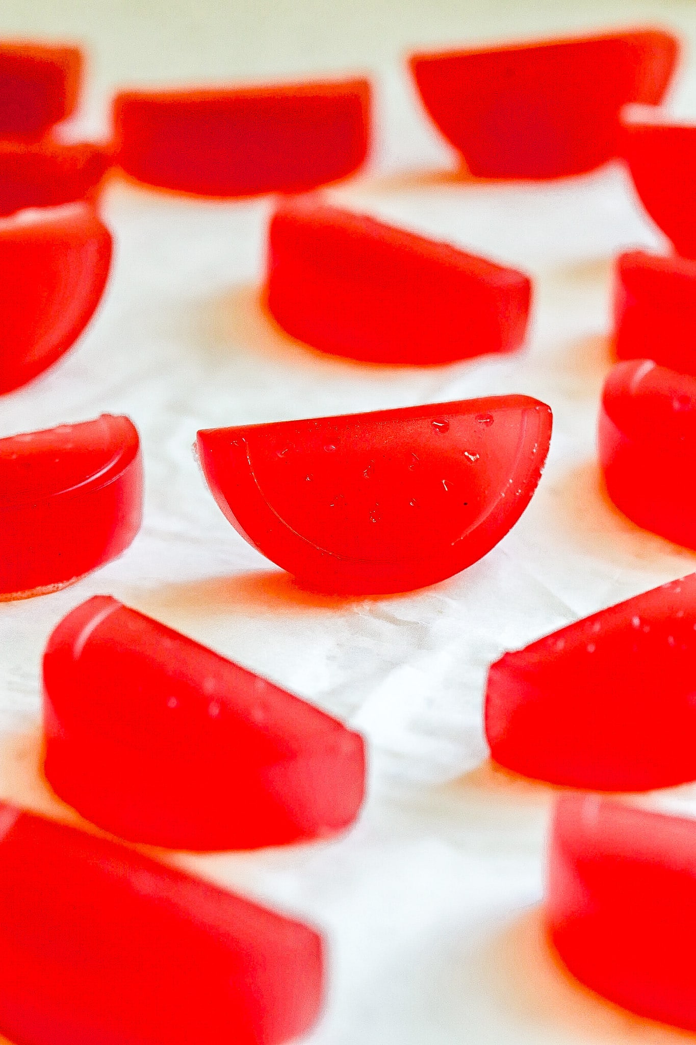 Close up shot of watermelon gummies on parchment paper.