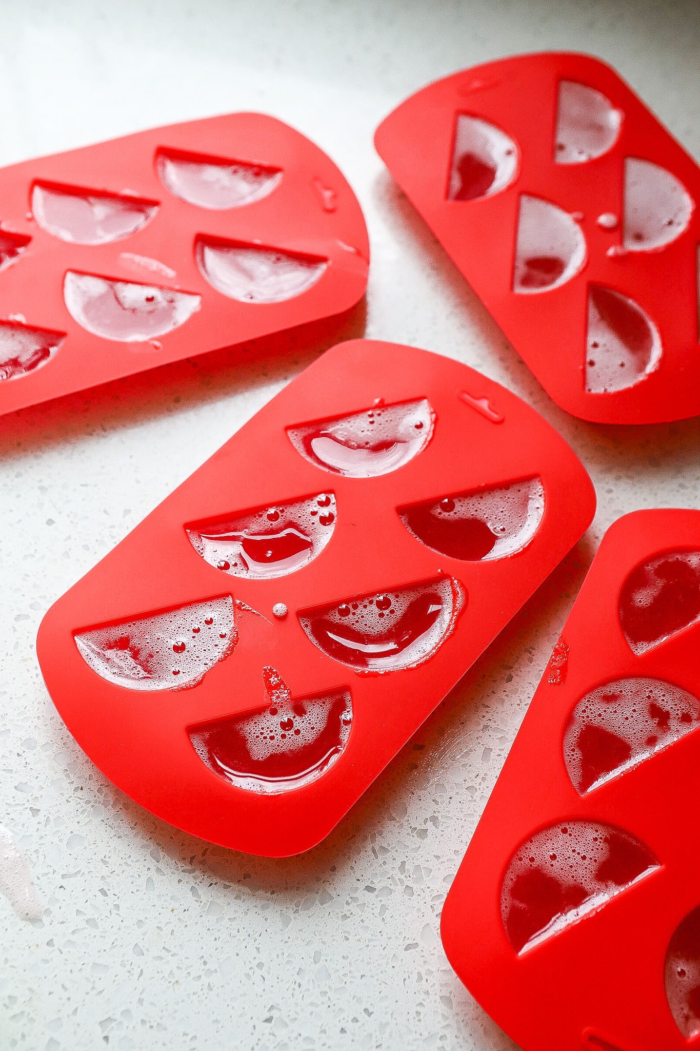 Side angle of mini watermelon protein gummies in silicone molds.