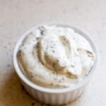 Side angle of easy protein ranch dressing in small white ramekin.