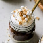 Side view of a mini jar of chocolate protein pudding pie with mini marshmallows on top.