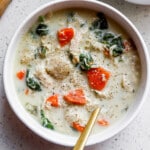 Top down view of low carb chicken gnocchi soup in white bowl with gold spoon.