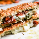 Side view of pesto chicken hot pocket on white plate.