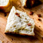 Close up shot of slice of parmesan cheese sourdough loaf with butter and salt.