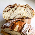 Side view of a loaf of sourdough bread cut in half stacked on top of each other.
