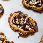 Close up shot of peanut butter chocolate smashed dates with peanuts and flakey coarse salt on top.