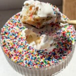 bite shot of protein dot cake with protein greek yogurt frosting and rainbow sprinkles