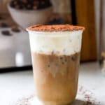 high protein tiramisu iced latte in a tall glass topped with mascarpone cold foam and cocoa
