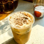 Iced protein pumpkin spice latte in a glass with pumpkin cream cold foam on top