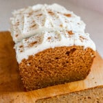 Protein pumpkin bread cut into slices showing the inside with greek yogurt cream cheese frosting on top